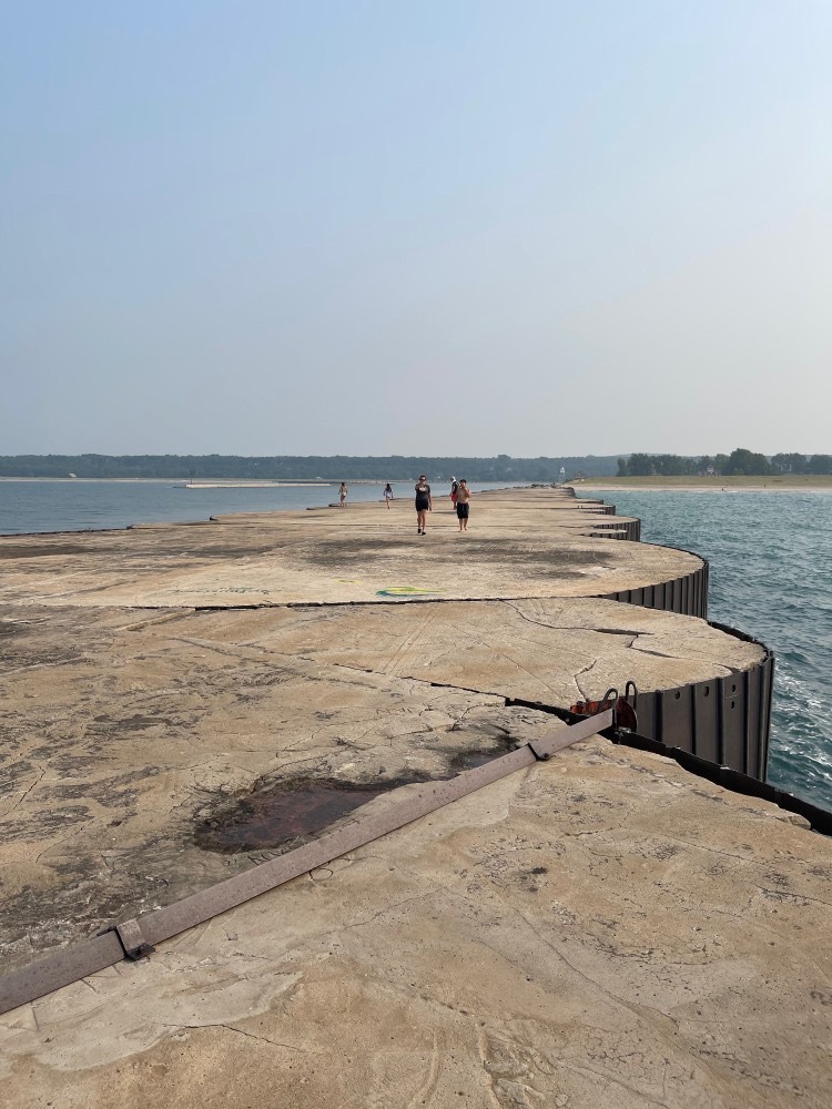 People walking out on the breakwall over Lake Superior