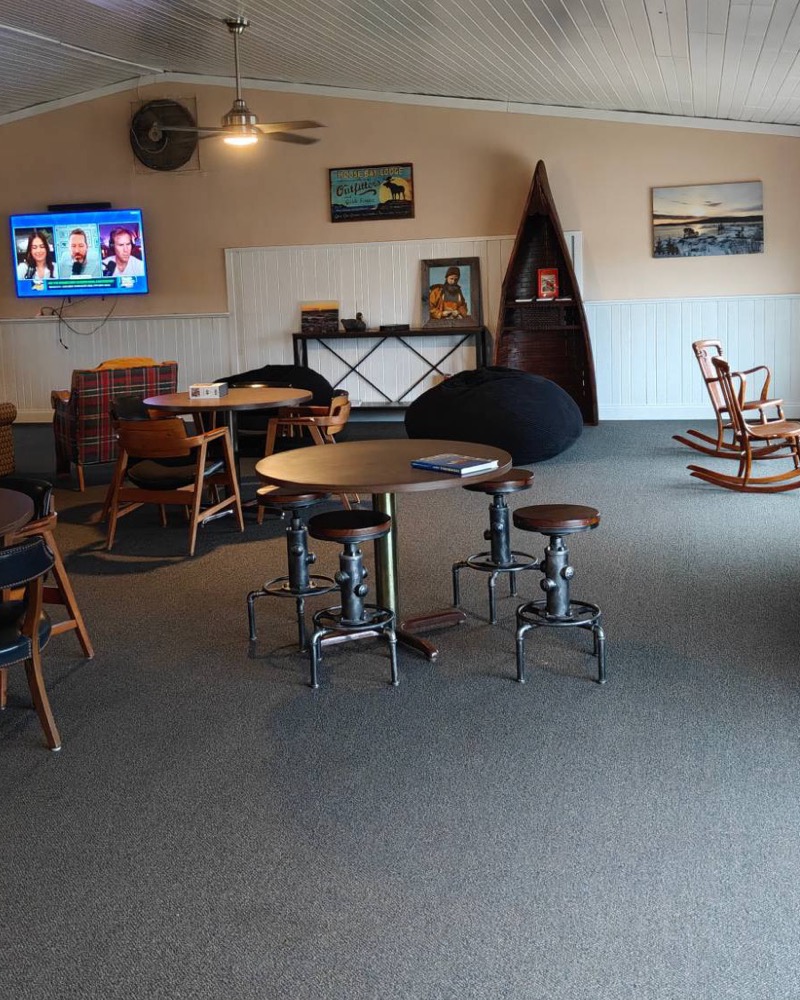 The big screen, rocking chairs and a canoe bookshelf in the Captain's Club
