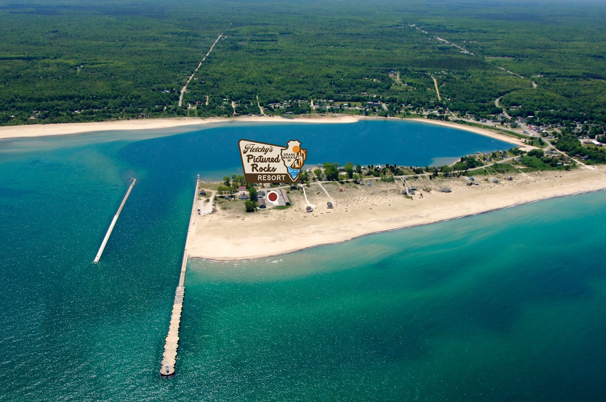 Coast Guard Point from the air: the harbor piers, the sand beach on Lake Superior, Fletchy's marked with its logo on the point and West Bay behind