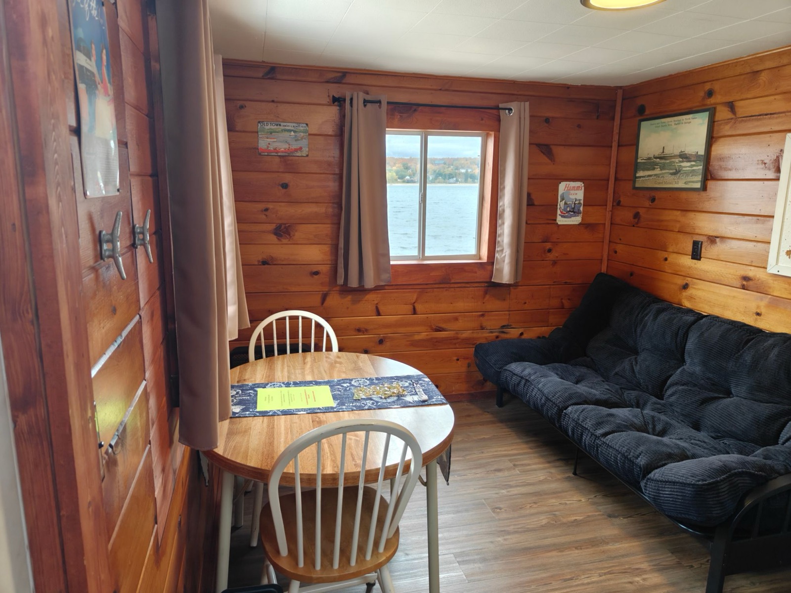 Knotty pine walls, a round table, a futon and a window on West Bay