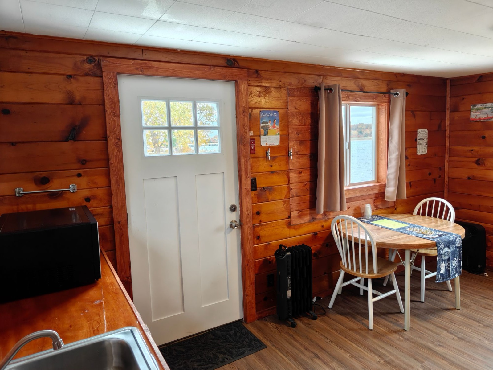 The cottage door and a table for two by the window over the water