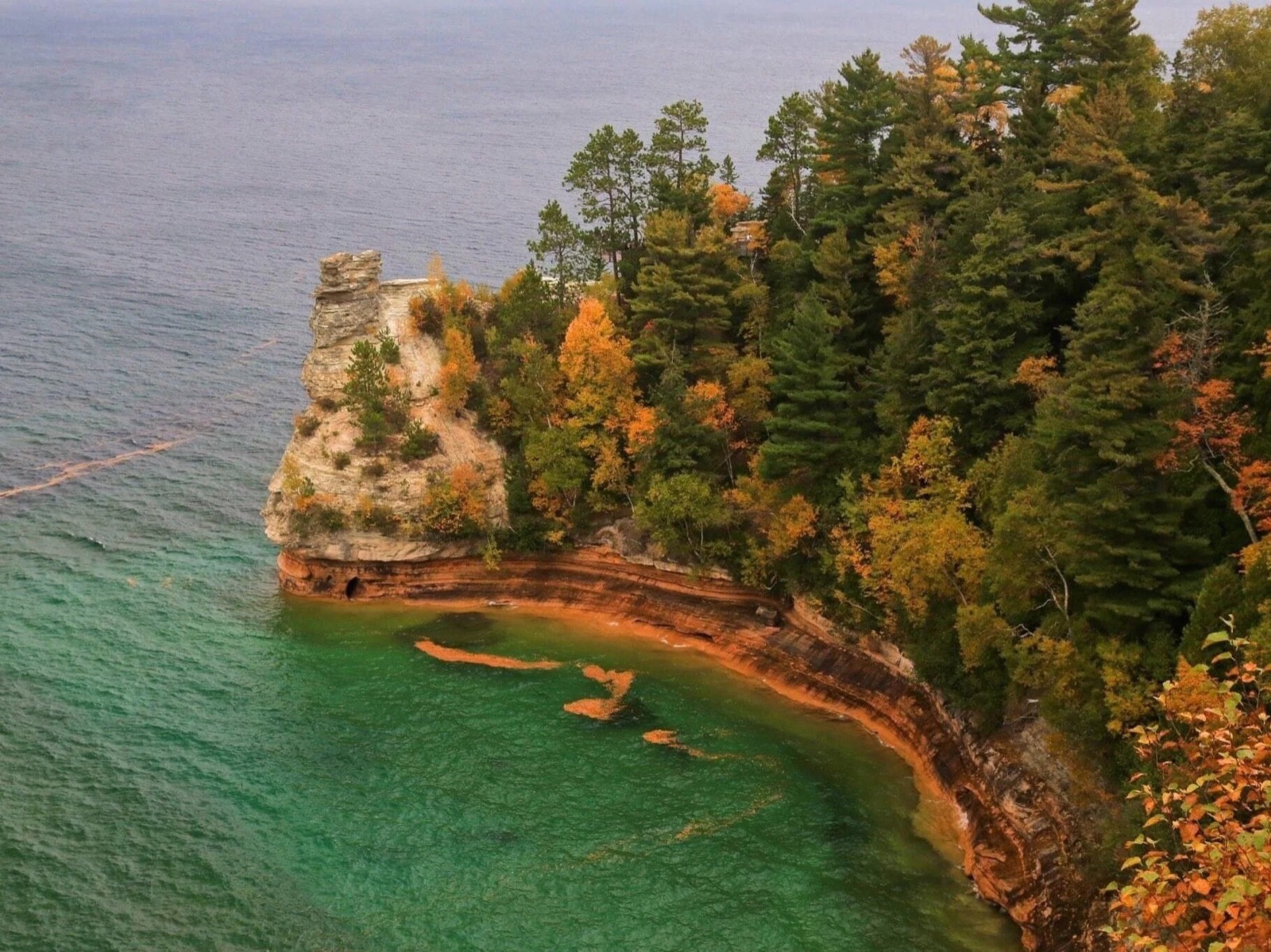 Miners Castle in fall color above the green water of Lake Superior