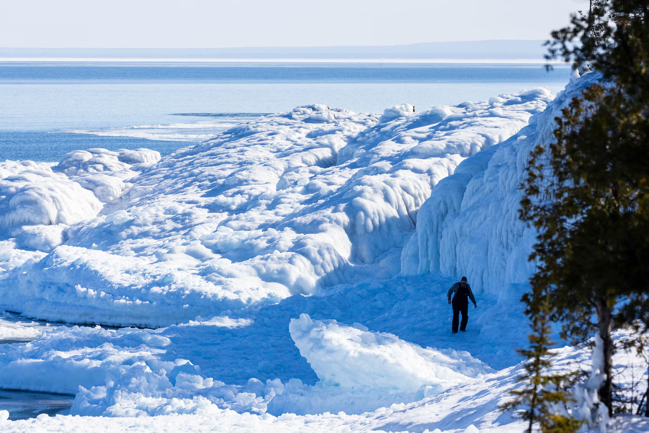 A walker among ice formations on the frozen shore of Lake Superior