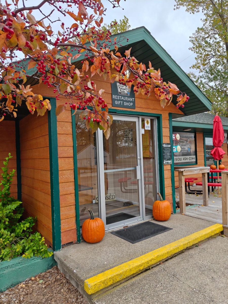 The restaurant and gift shop door under a crab apple tree, pumpkins on the step